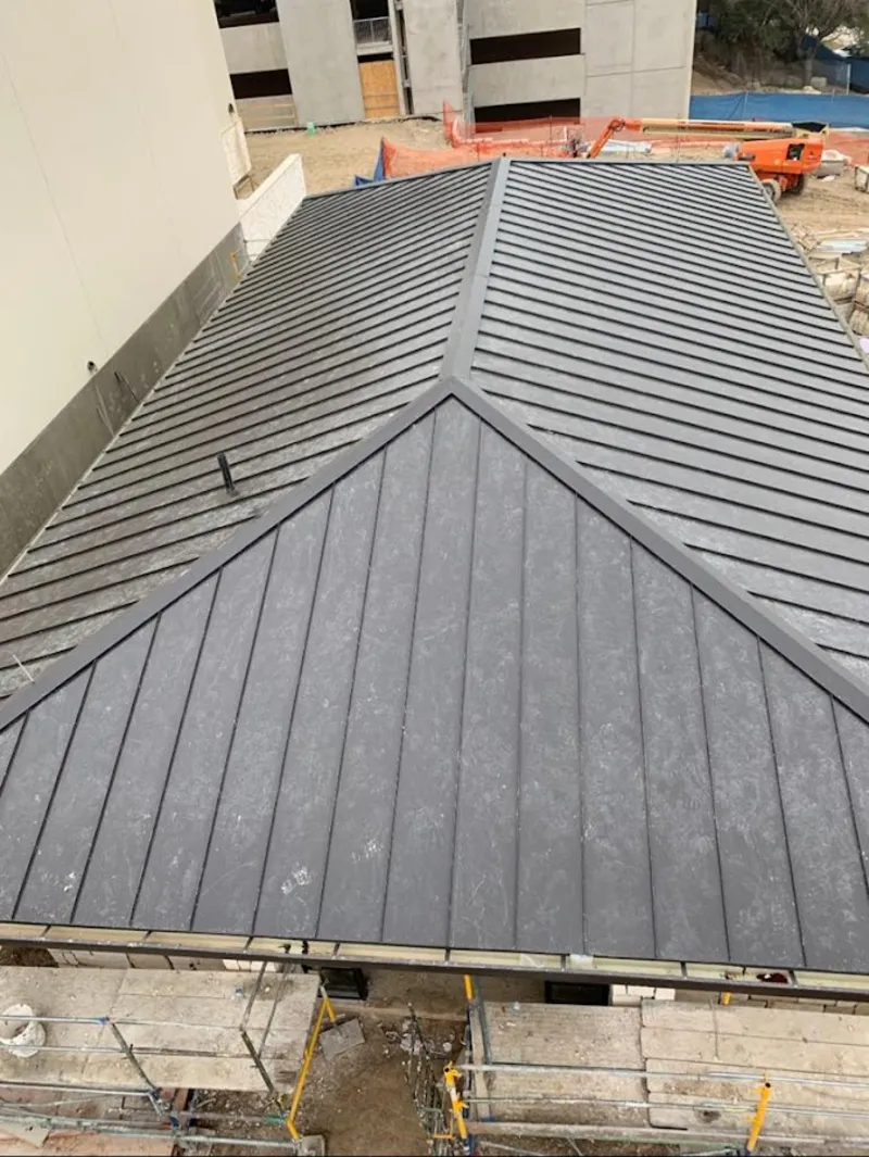 Commercial metal roof construction with crane equipment in Hubbard